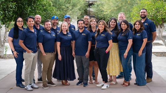 People wearing blue polo shirts standing together as a group