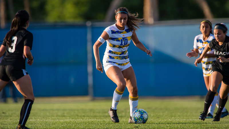 CSUB women's soccer player kicking the ball on the pitch